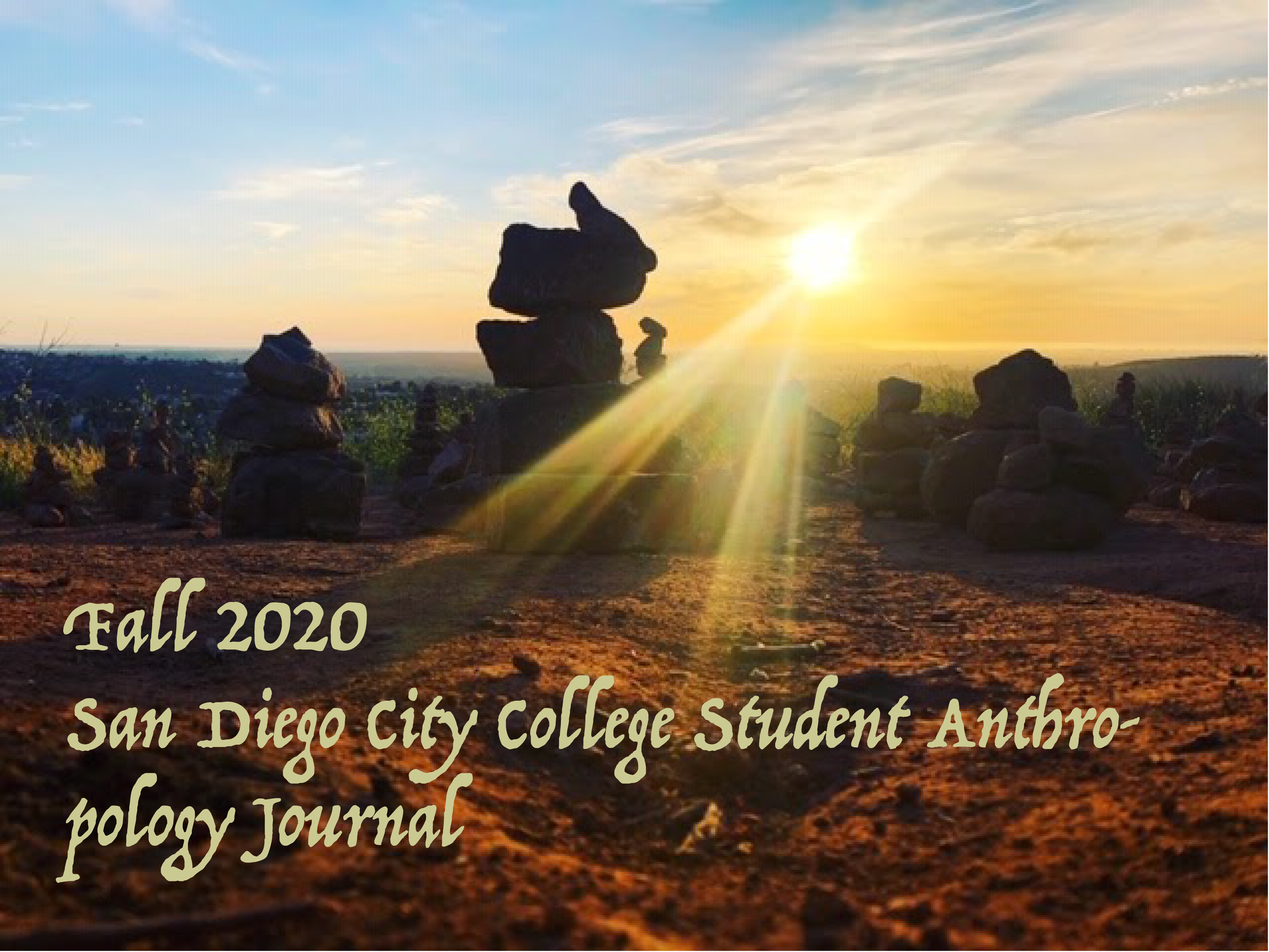 Fall 2020 San Diego City College Student Anthropology Journal; photo of a sunset shining rays of light through stacks of large boulders.